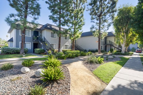 a house with a sidewalk and landscaping in front of it